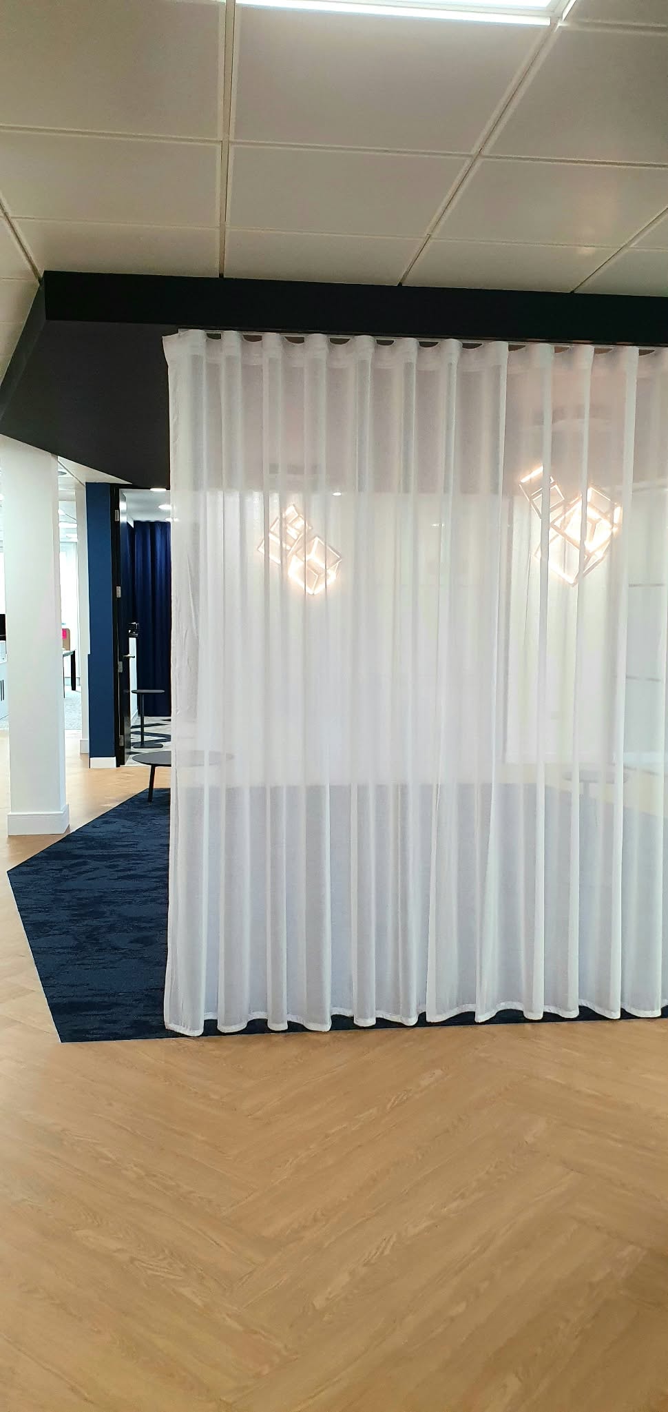 Sheer curtains dividing a commercial space — Sustainable Shutters & Blinds