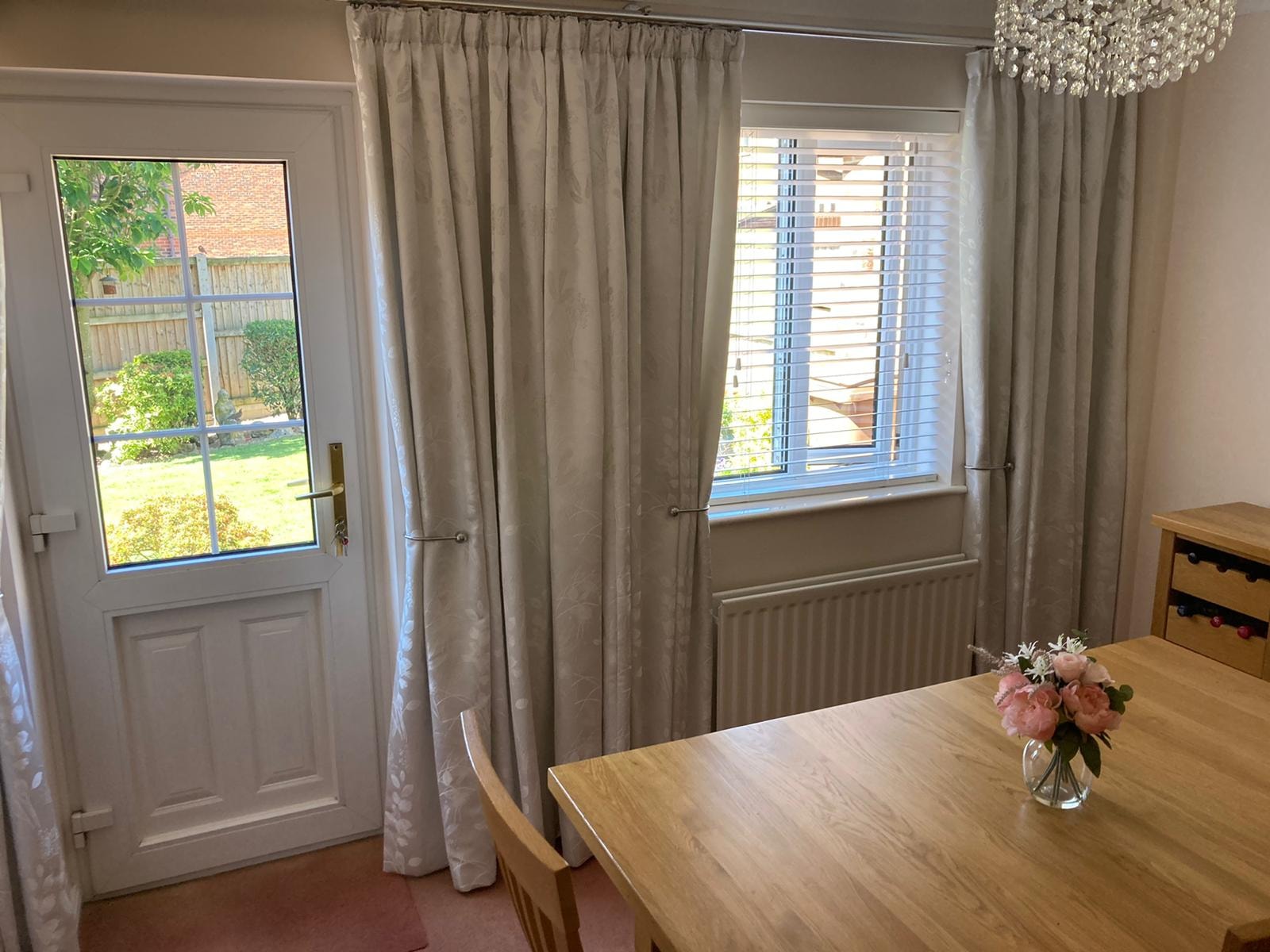 Blinds in a dining room with garden view — Sustainable Shutters & Blinds