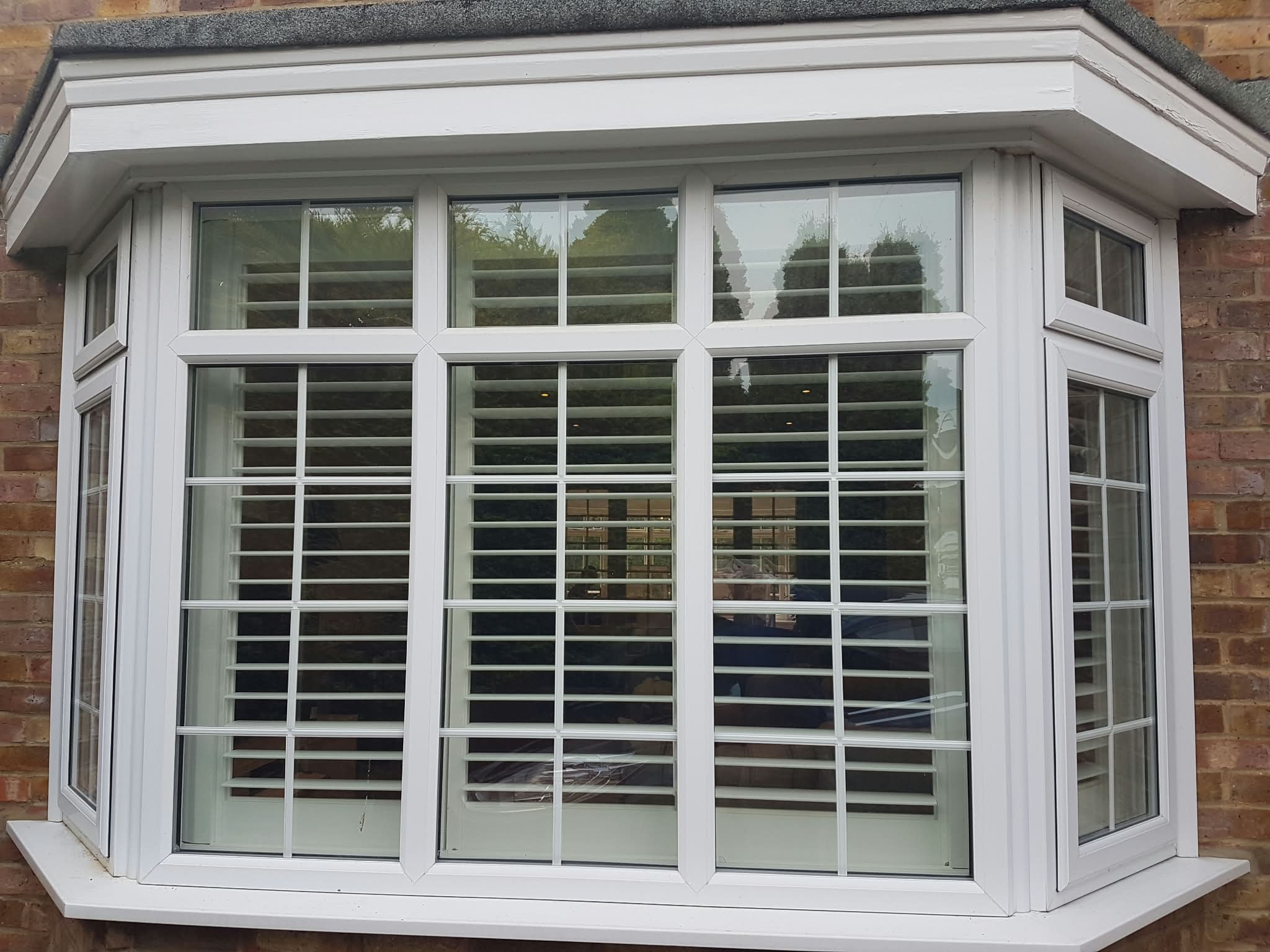 White bay window with plantation shutters — Sustainable Shutters & Blinds