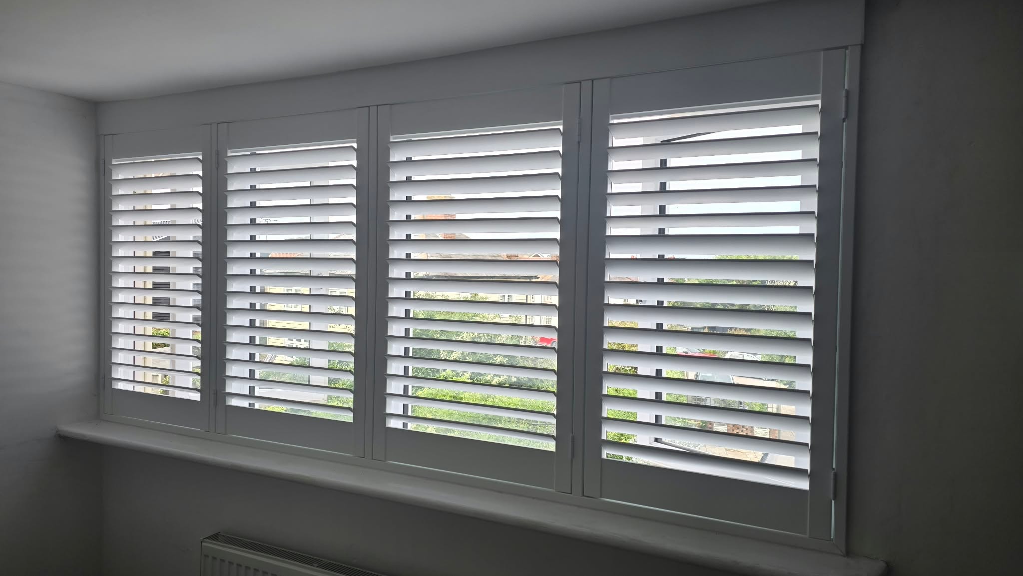 Grey shutters across a wide window — Sustainable Shutters & Blinds