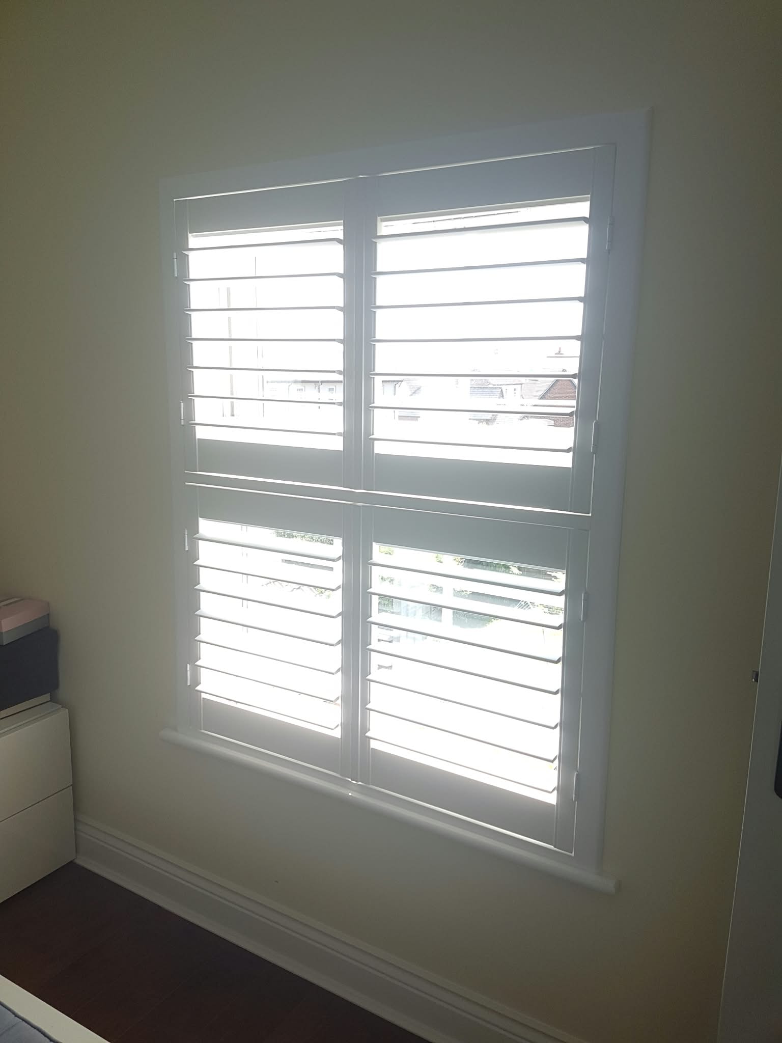 White plantation shutters on an interior window — Sustainable Shutters & Blinds