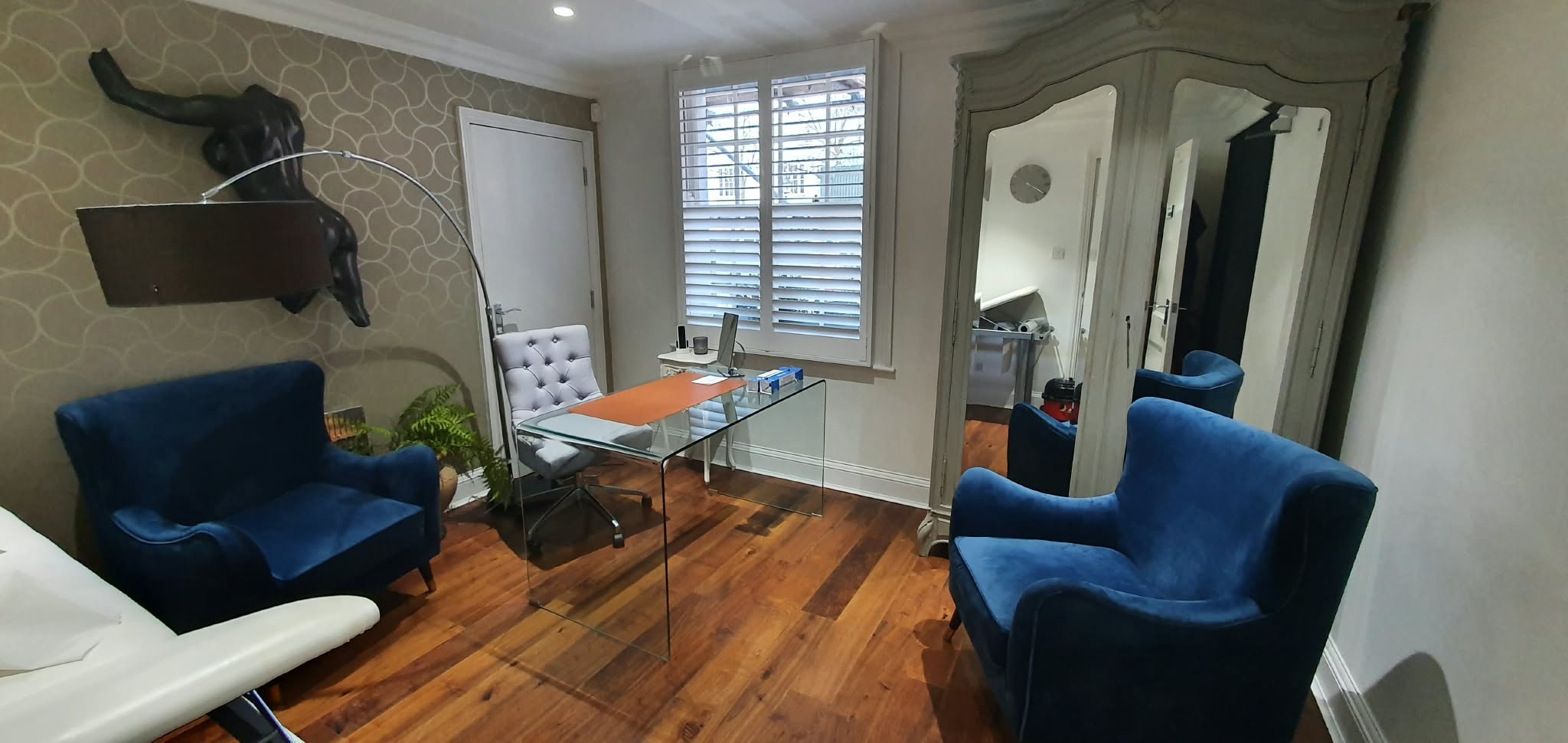 Shutters in a home office with blue chairs — Sustainable Shutters & Blinds