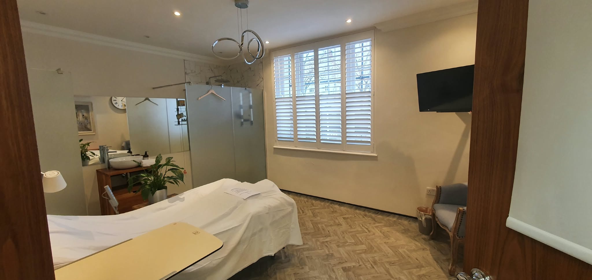 White shutters in a treatment room viewed from doorway — Sustainable Shutters & Blinds