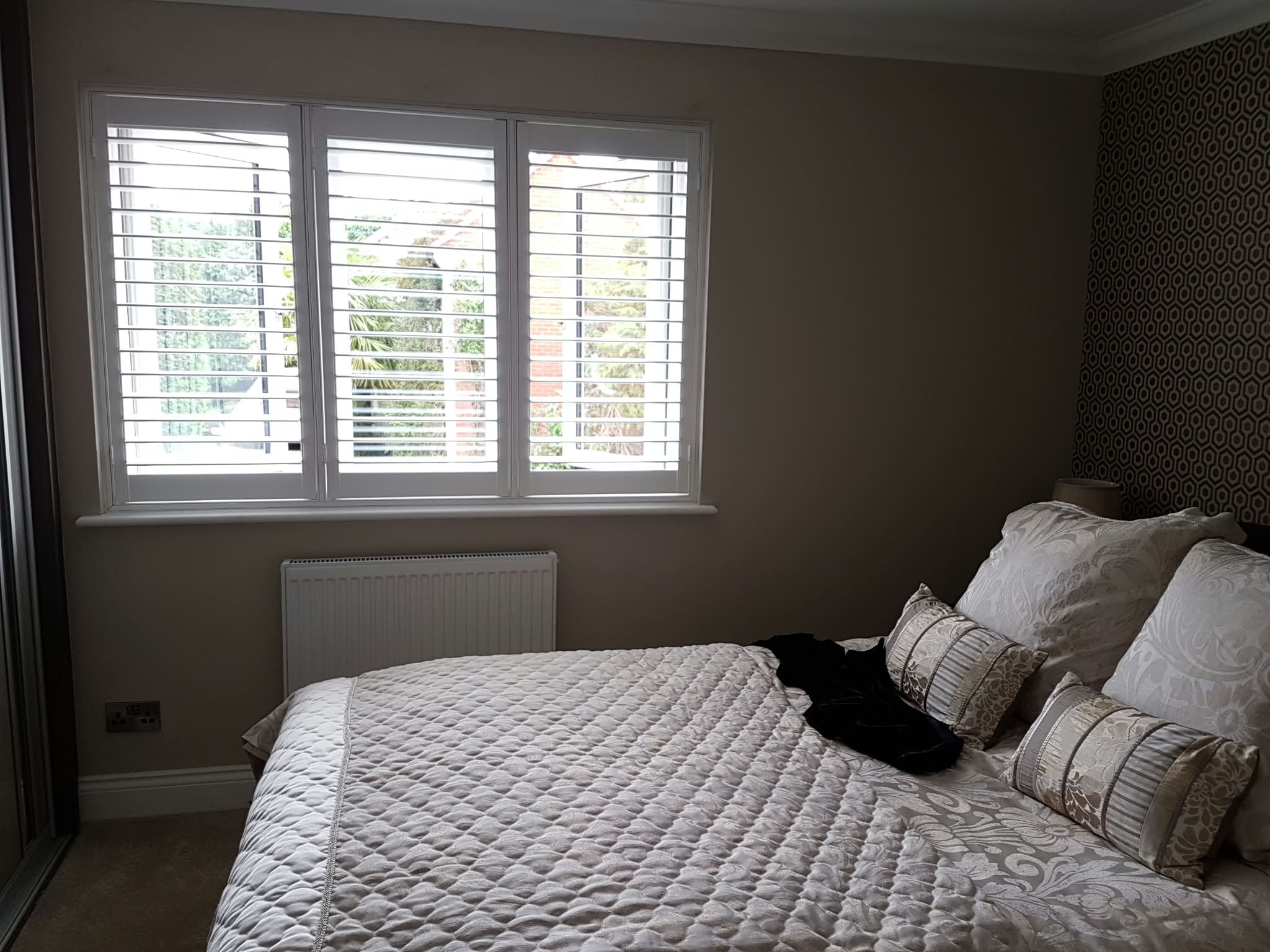 White shutters in a bedroom — Sustainable Shutters & Blinds