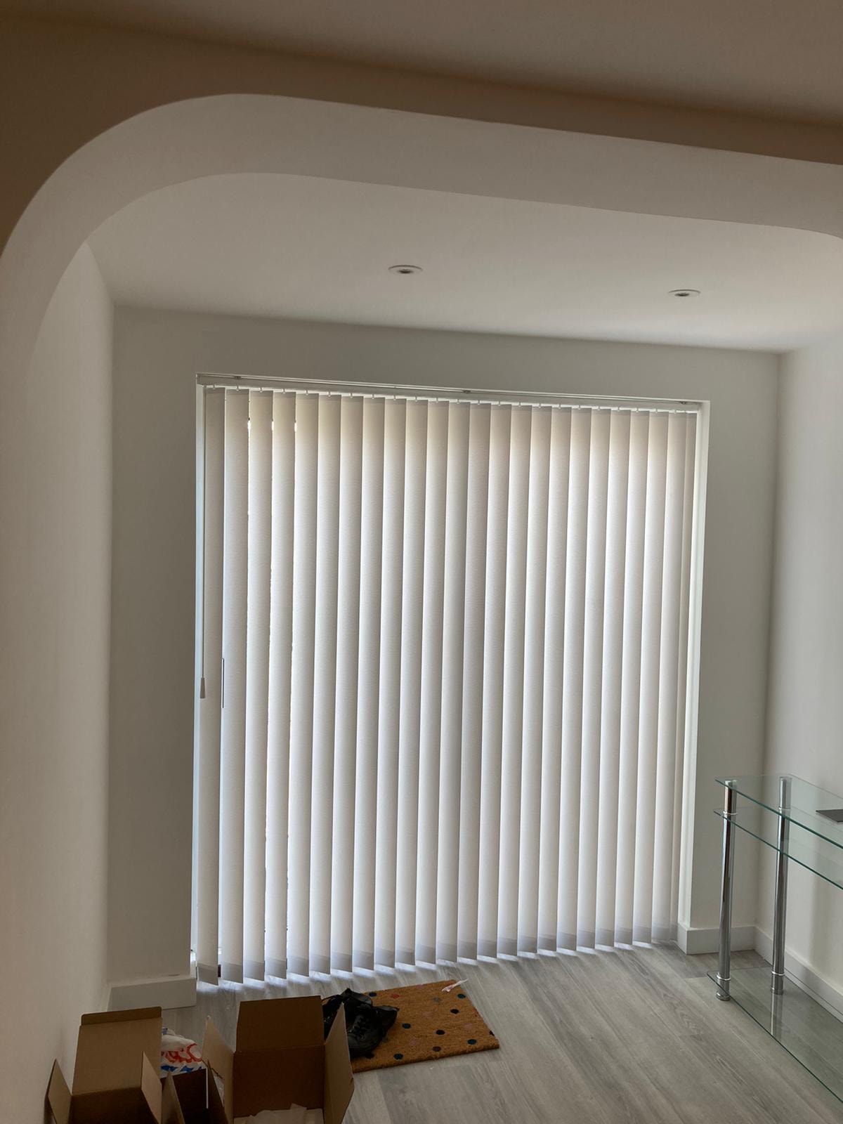 White vertical blinds on a large window under an arch — Sustainable Shutters & Blinds