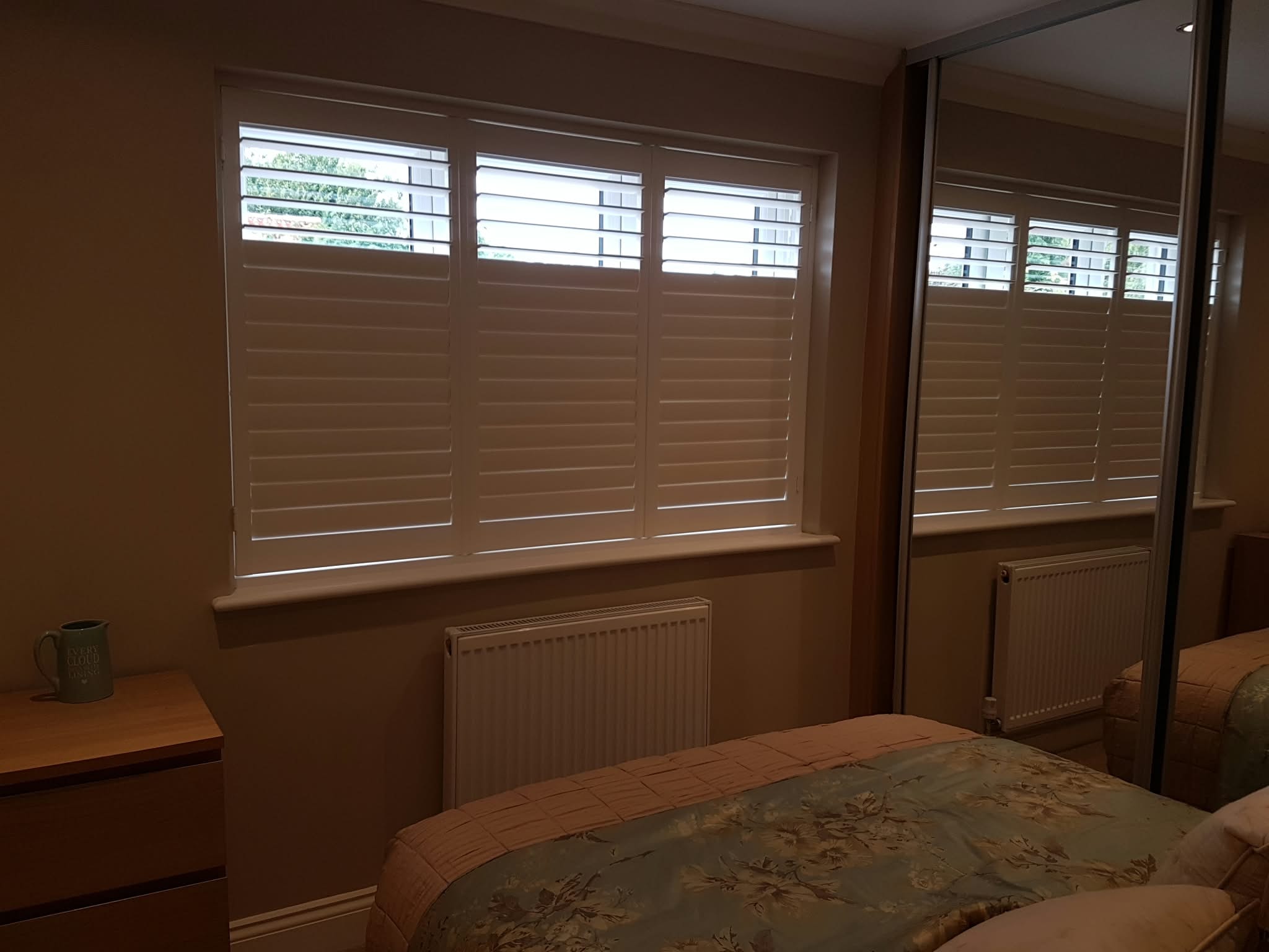 Shutters in a bedroom with mirror — Sustainable Shutters & Blinds